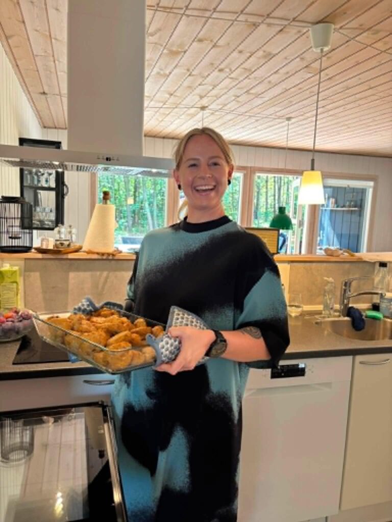 Trine, der ser meget glad ud og holder et fad med kyllingefrikadeller